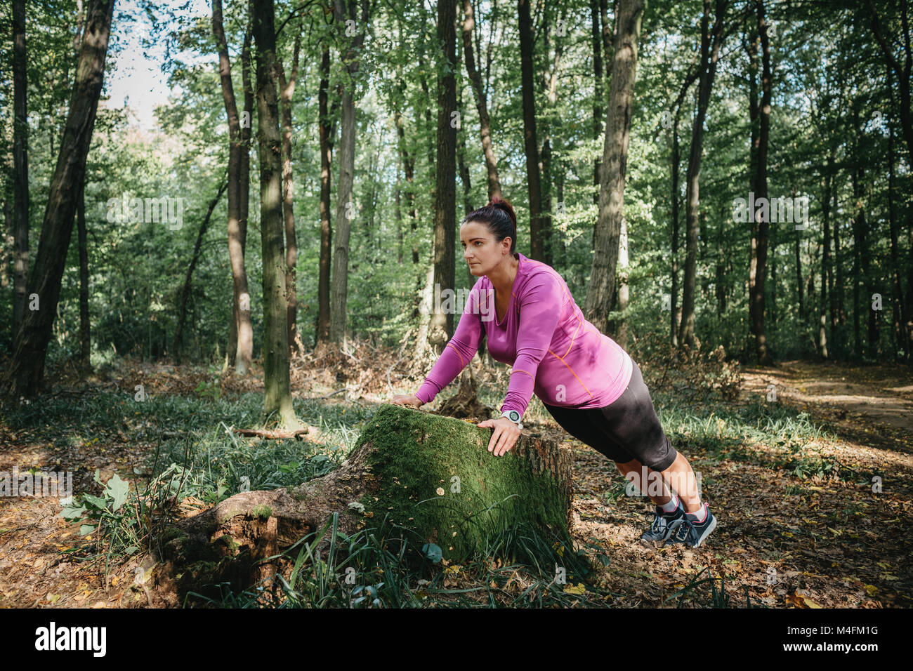 Full length portrait of a female jogger warming up on her own and getting ready for a jog. Stock Photo