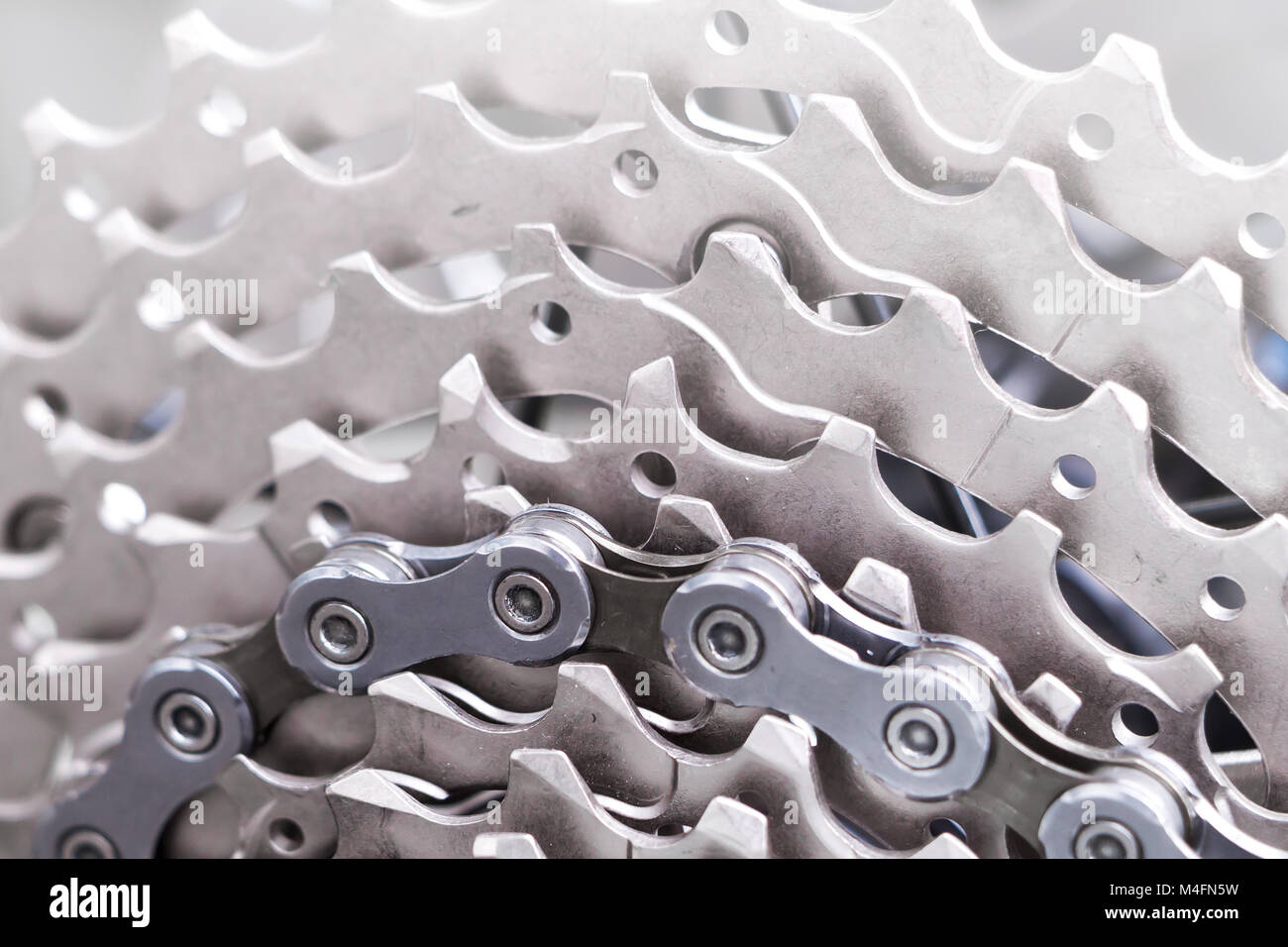 Mountain bike wheel and gear detail with a new clean chain and metal chain rings. Stock Photo