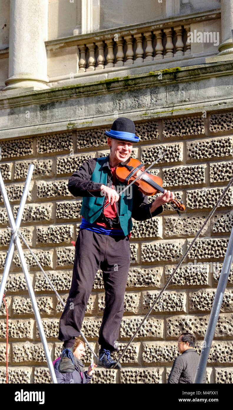 Bath, UK. 16th February 2018. A bright winters day in Bath outside the Roman Baths. Kwabana Lindsay performs his act in the center of Bath. The 'Fiddler on a Rope' has performed all over the counntry, showing off his own form of musical equilibistics. Credit: JMF News/Alamy Live News Stock Photo