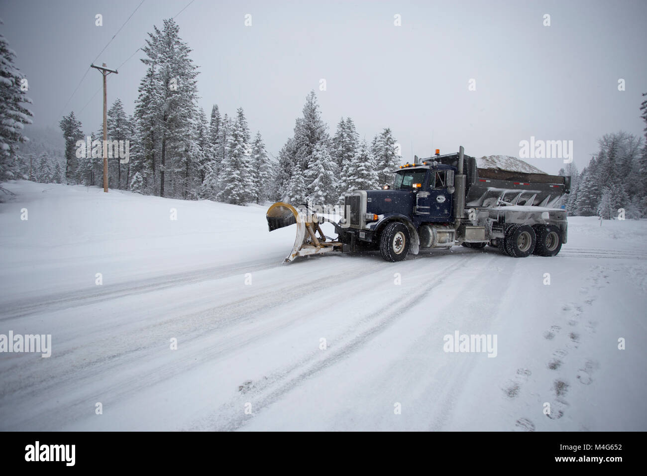 Sanders County, Montana, USA. 16th Feb, 2018. 02/16/2018 Snow event. Snow storm. A tandem axle Peterbuilt snow plow truck plowing the snow and sanding the road on Highway 56, Bull Lake Road, at the intersection of the South Fork of Bull River Road, in Sanders County, Montana. The road is located in a remote section of the Cabinet Mountains, about 20 miles north of Noxon, Montana. The area is being hit with heavy snow, coming in from the west. The storm should last several days. Credit: Martin Battilana Photography - Alamy/Alamy Live News Stock Photo