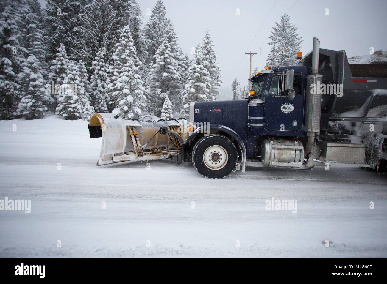 Sanders County, Montana, USA. 16th Feb, 2018. 02/16/2018 Snow event. Snow storm. A Sanders County tandem axle Peterbuilt snow plow truck plowing the snow and sanding the road on Highway 56, Bull Lake Road, at the intersection of the South Fork of Bull River Road, in Sanders County, Montana. The road is located in a remote section of the Cabinet Mountains, about 20 miles north of Noxon, Montana. The area is being hit with heavy snow, coming in from the west. The storm should last several days. Credit: Martin Battilana Photography - Alamy/Alamy Live News Stock Photo