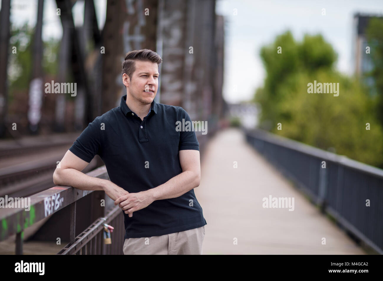 Portrait of a man posing on a city bridge. Medium shot. Stock Photo