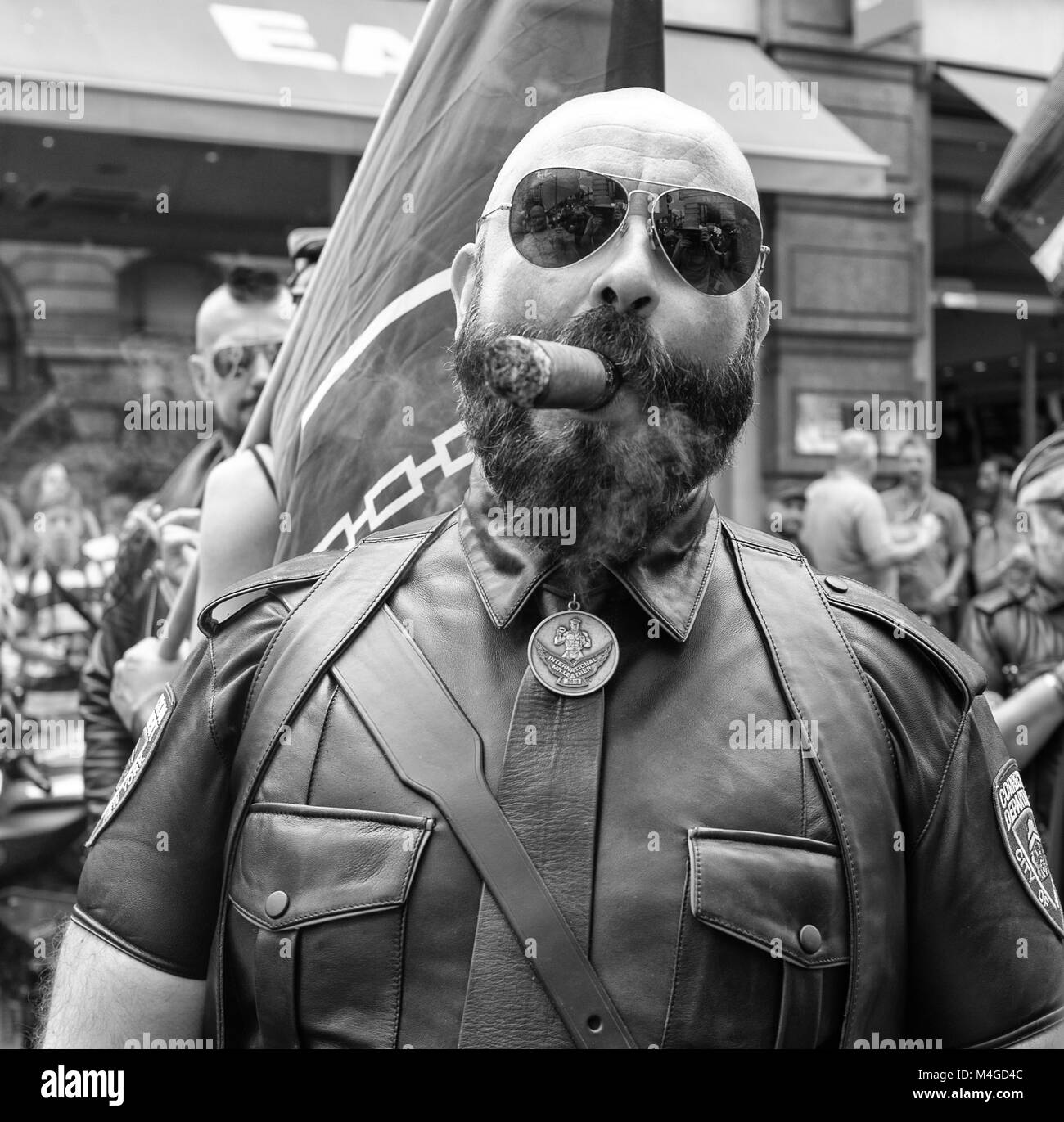 Black & White Photograph of a man smoking his cigar at The Pride in London Parade, London, England, UK. Credit: London Snapper Stock Photo