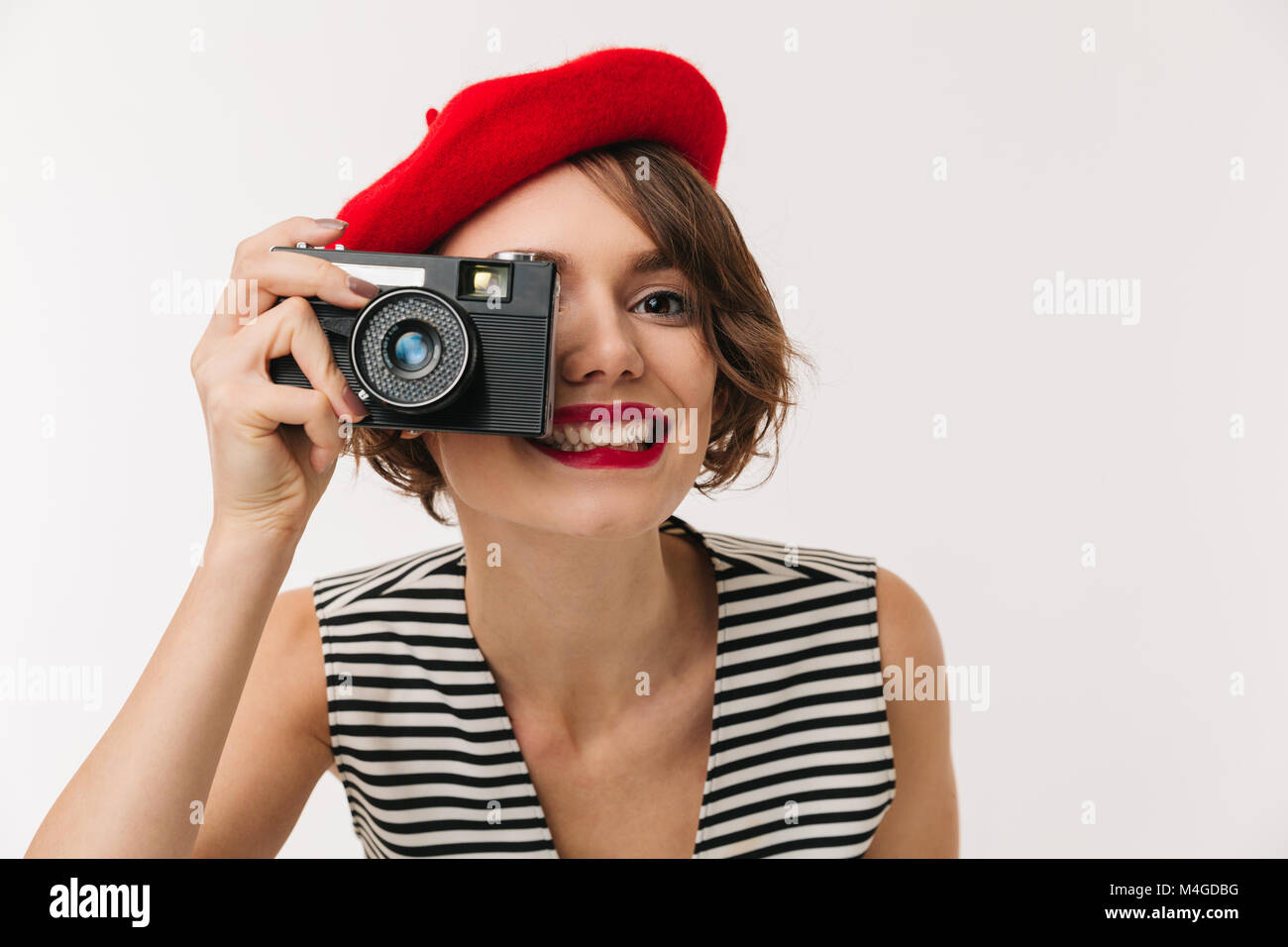 Portrait of a smiling woman wearing red beret taking picture with a