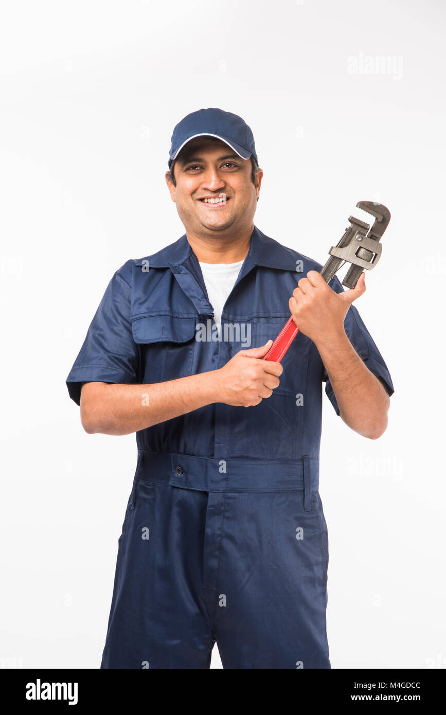 Indian plumber posing with Pipe wrench or plumbing spanner, standing