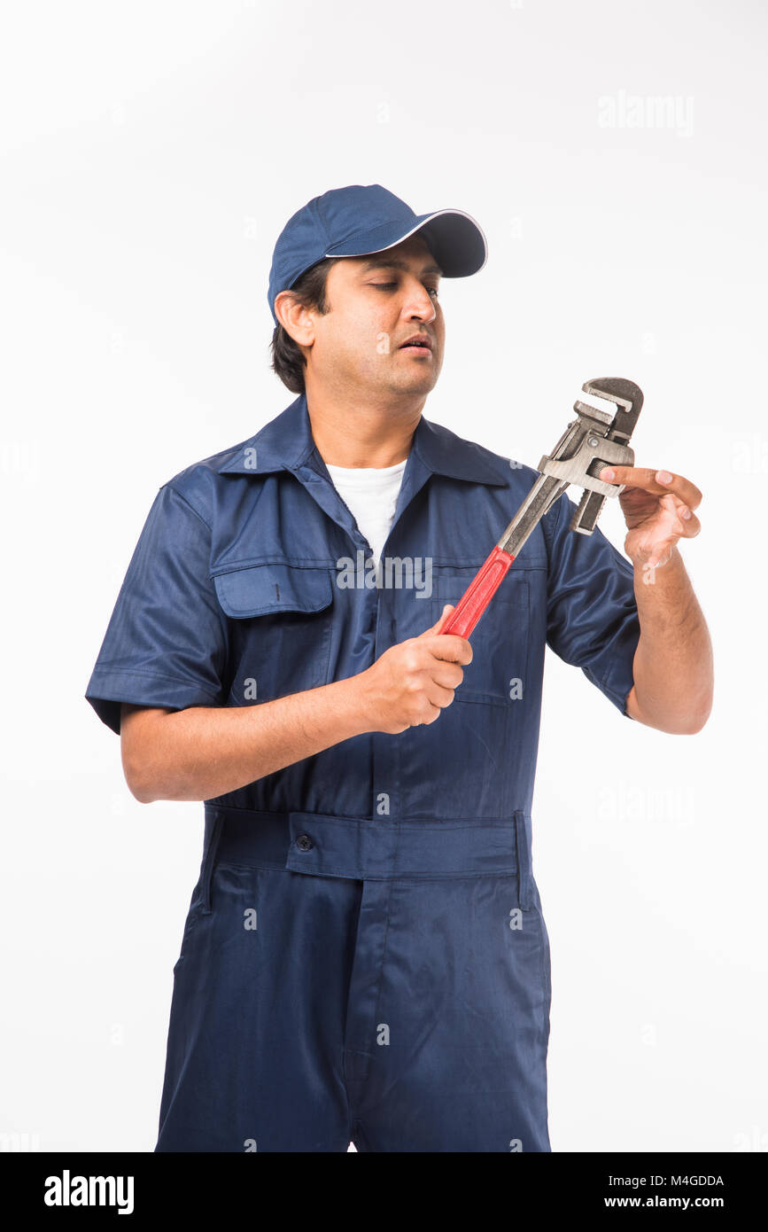 Indian plumber posing with Pipe wrench or plumbing spanner, standing