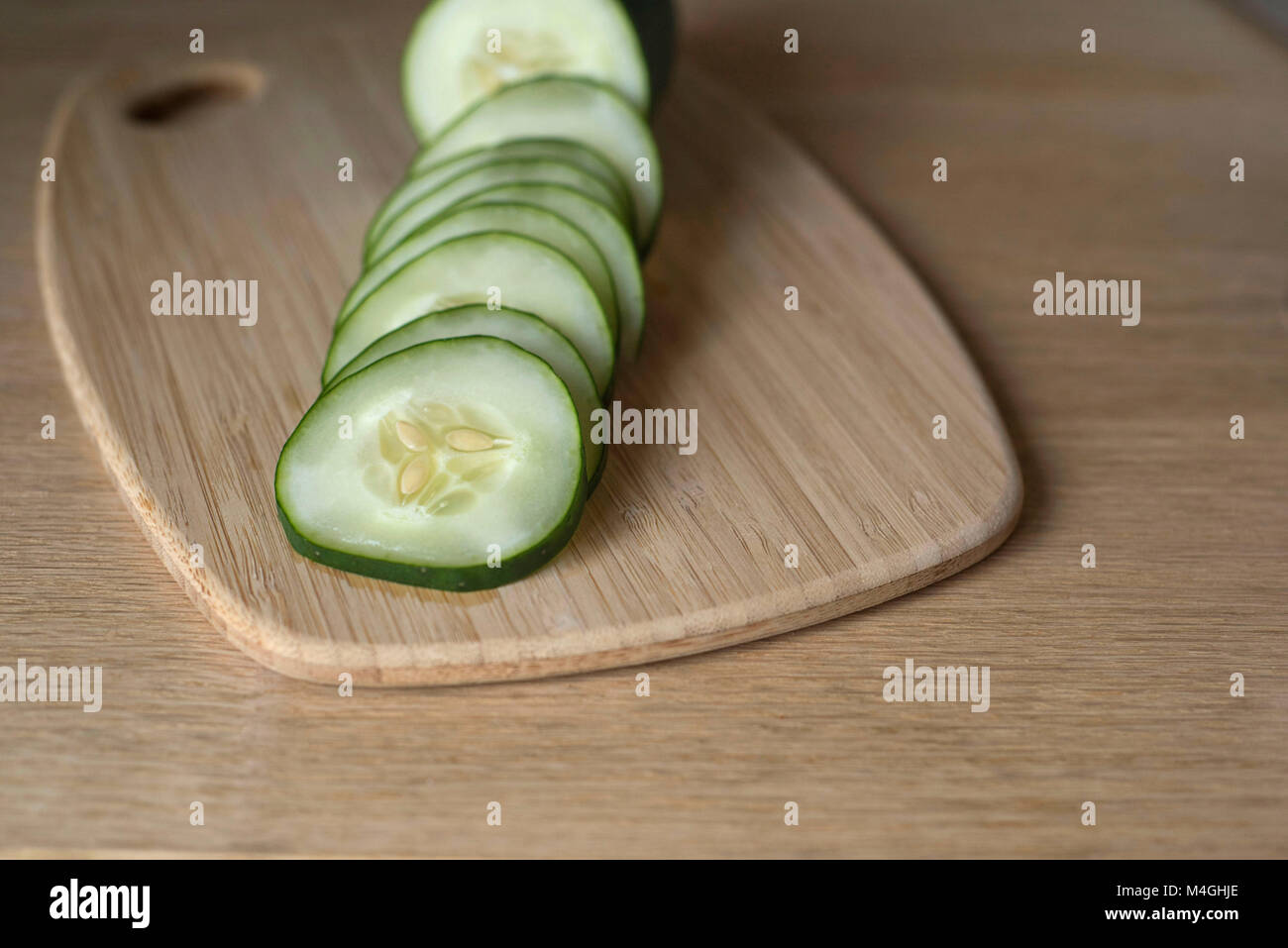 Cucumber Slices on a Bamboo Cutting Board Ready to Eat Stock Photo