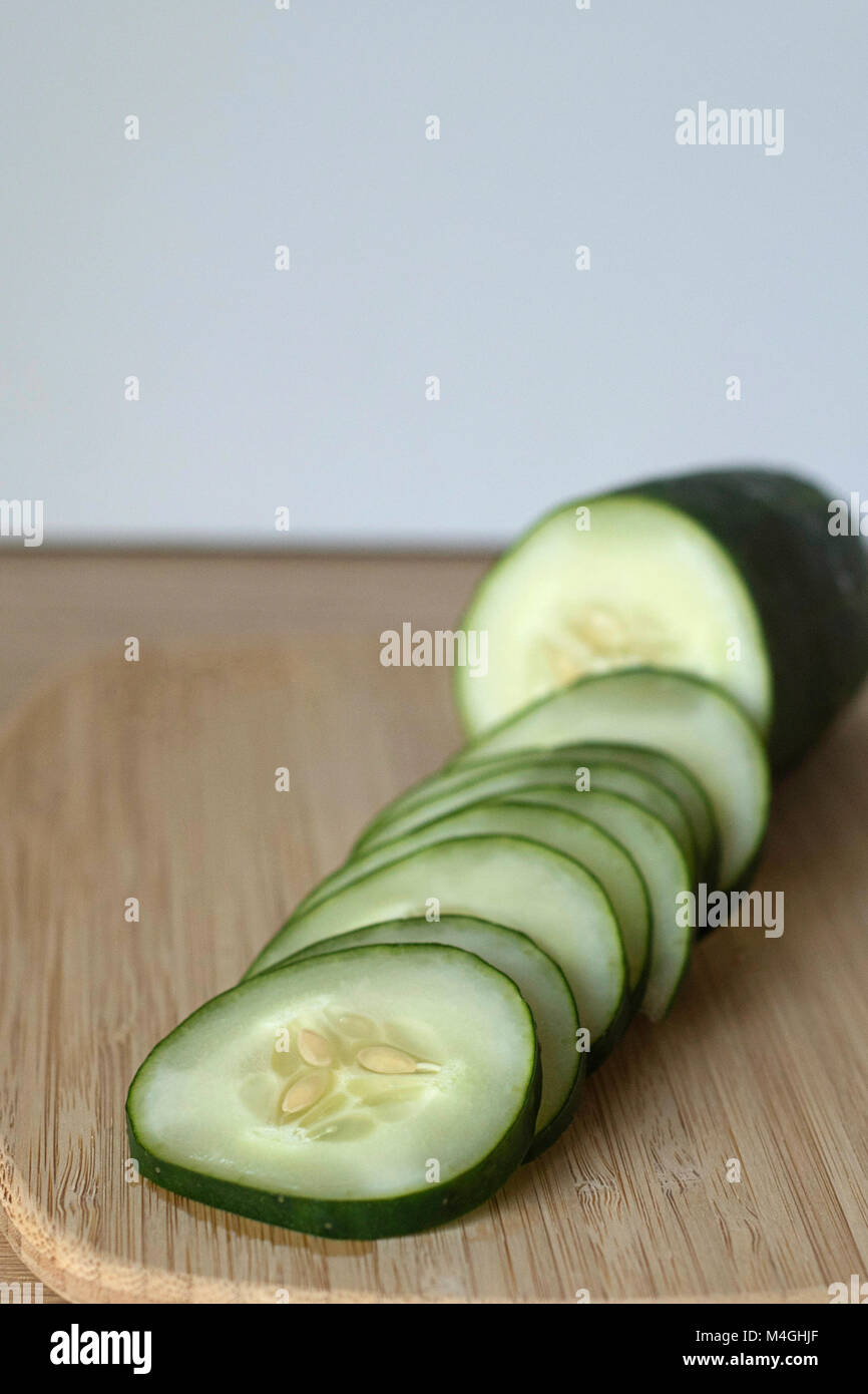 Cucumber Slices in Progress on a Wood Counter Ready for A Healthy Snack Stock Photo