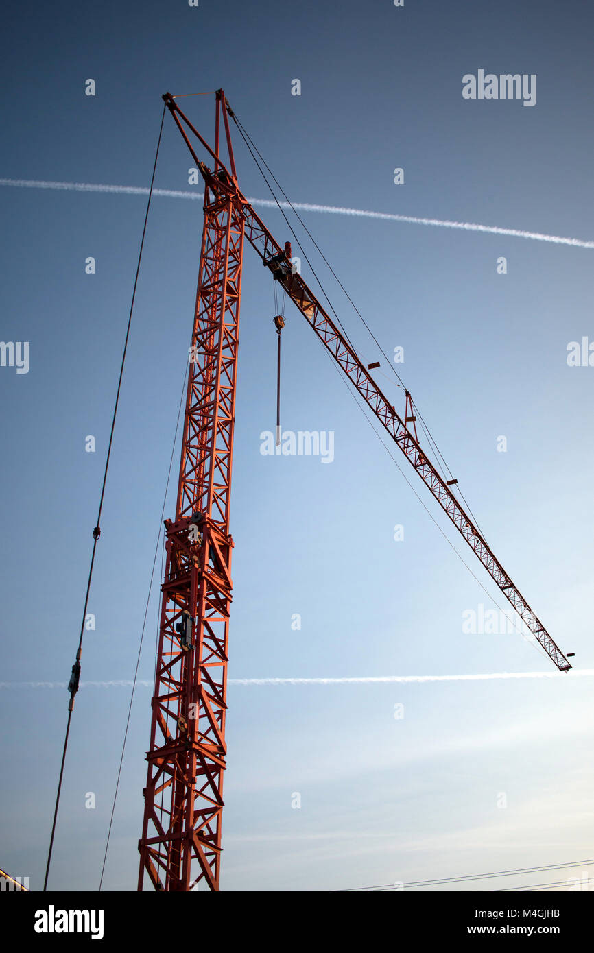 Red eracted crane in a vertical with contrails or chemtrails with blue sky at later daytime, in 2017 Stock Photo