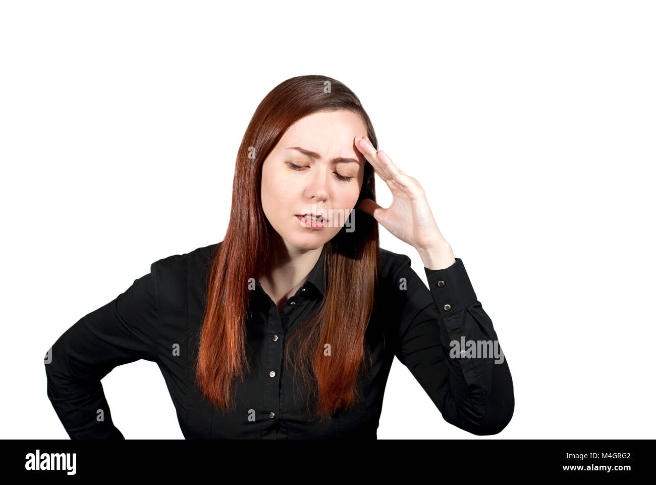 young woman on a white background has put a hand to her forehead and closed her eyes, expressing deep thoughtfulness or suffering from a headache Stock Photo