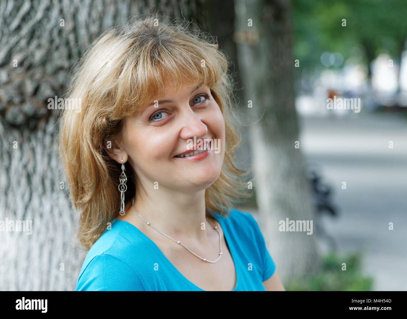 Portrait of a smiling woman in the park Stock Photo - Alamy