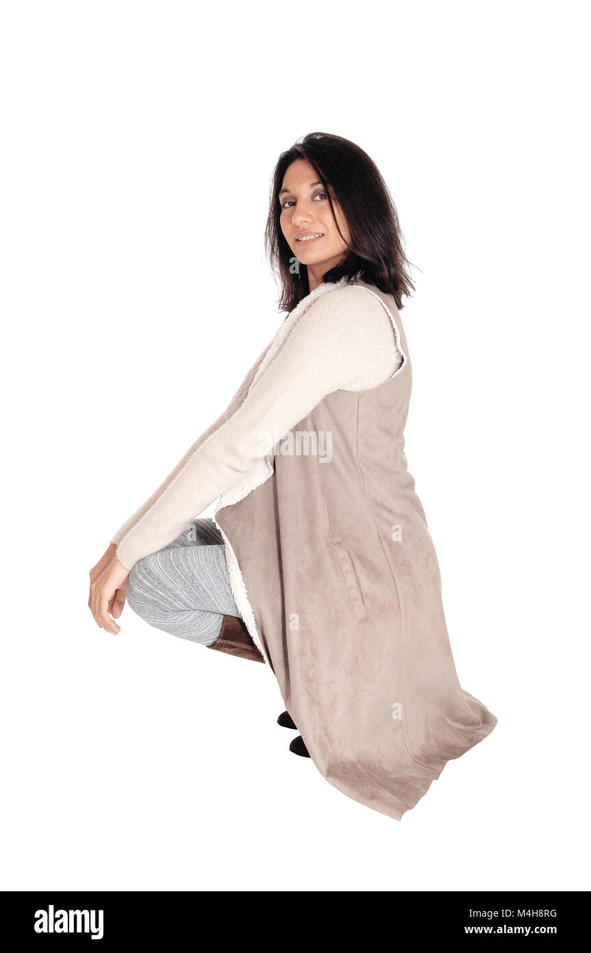 Woman crouching in deerskin coat. Stock Photo