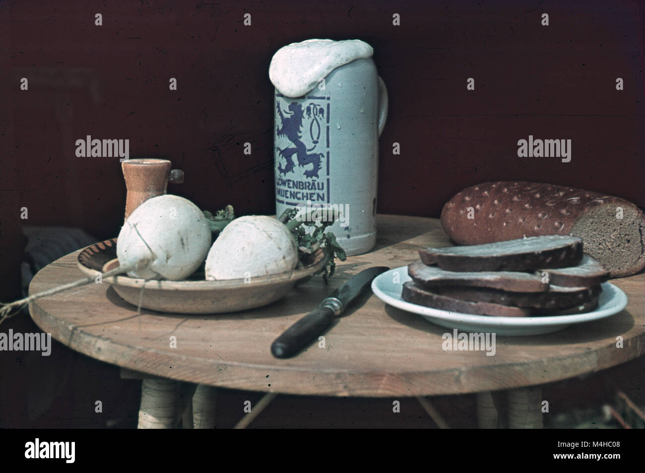 Bavarian Brotzeit (savory snack) with butter, bread and radish on a wooden table. Stock Photo