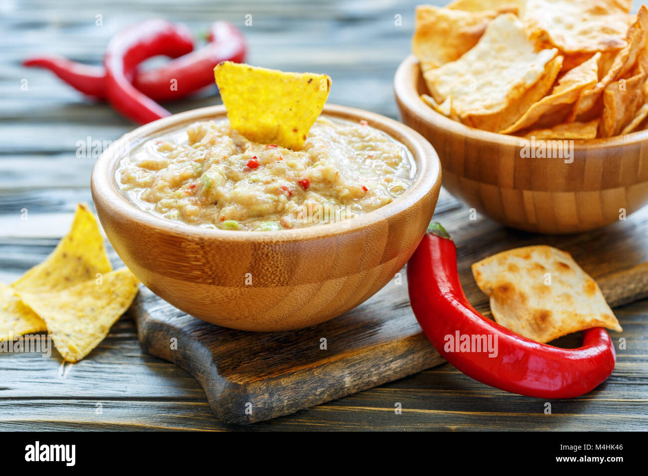 Guacamole in a wooden bowl and with tortilla chips. Stock Photo