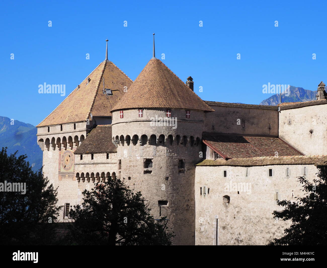 View of stony walls and towers of medieval Chateau de Chillon castle in Switzerland at alpine Lake Geneva in Montreux city, Canton of Vaud, clear blue Stock Photo