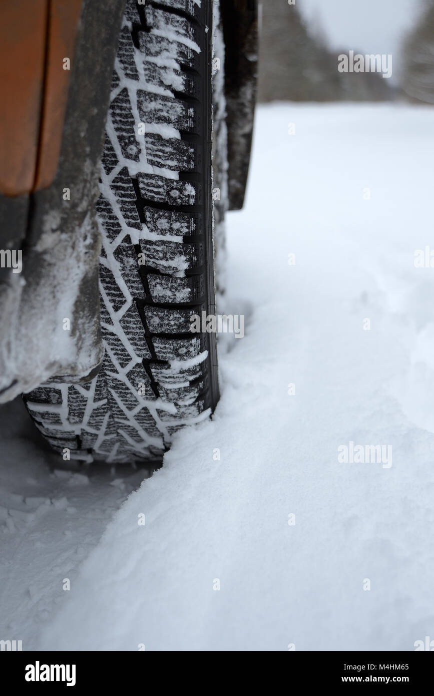 Wheel with a winter tire on a winter road with a curved plan Stock Photo