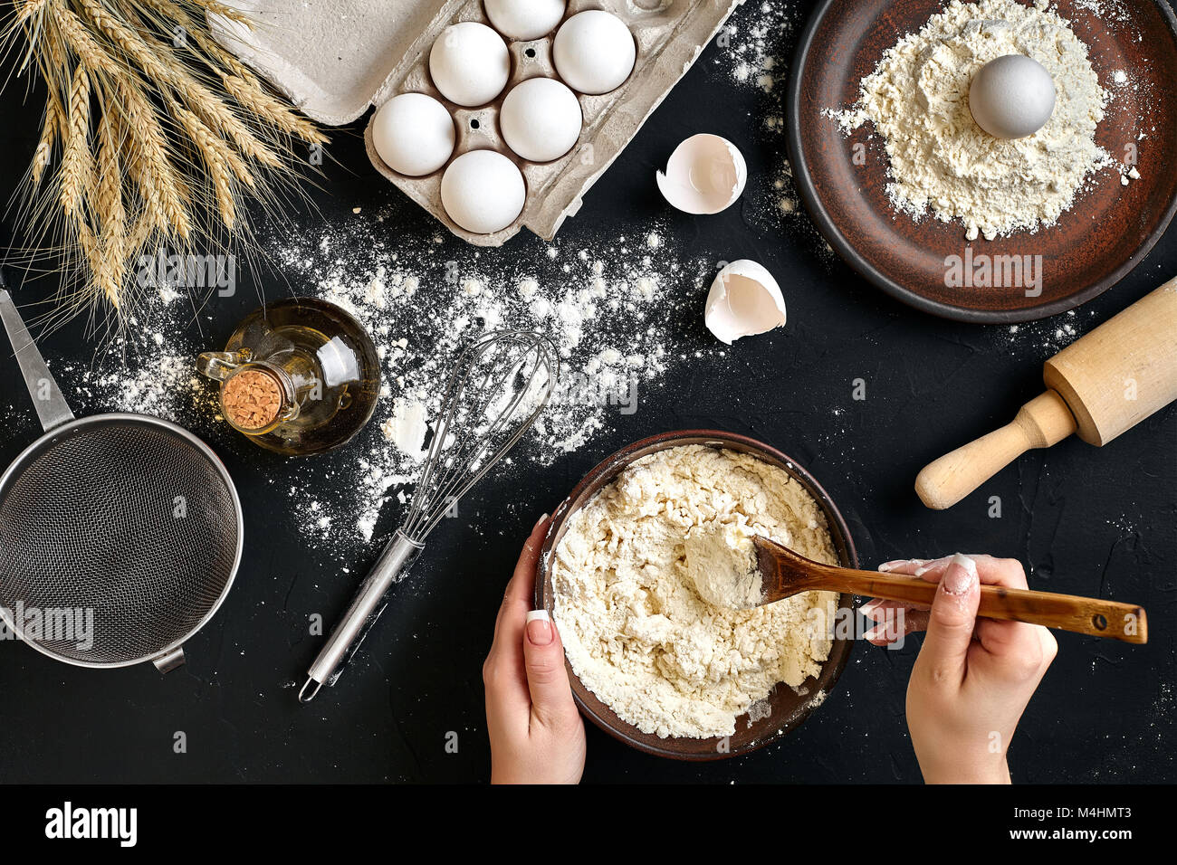 https://c8.alamy.com/comp/M4HMT3/female-hands-making-mixing-dough-in-brown-bowl-on-black-table-baking-M4HMT3.jpg