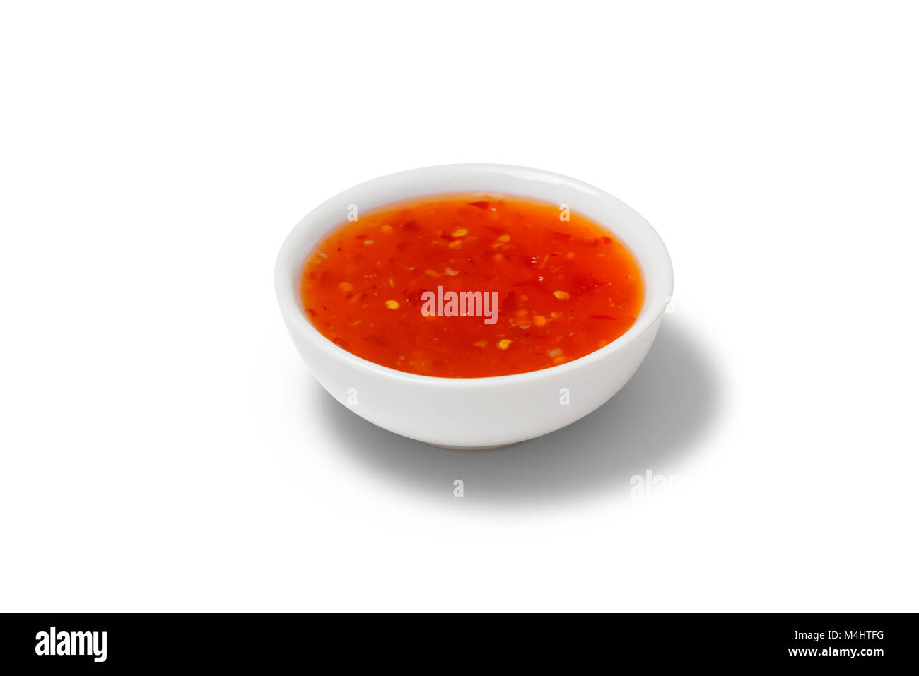 Chilli sauce in a gravy boat on white background Stock Photo