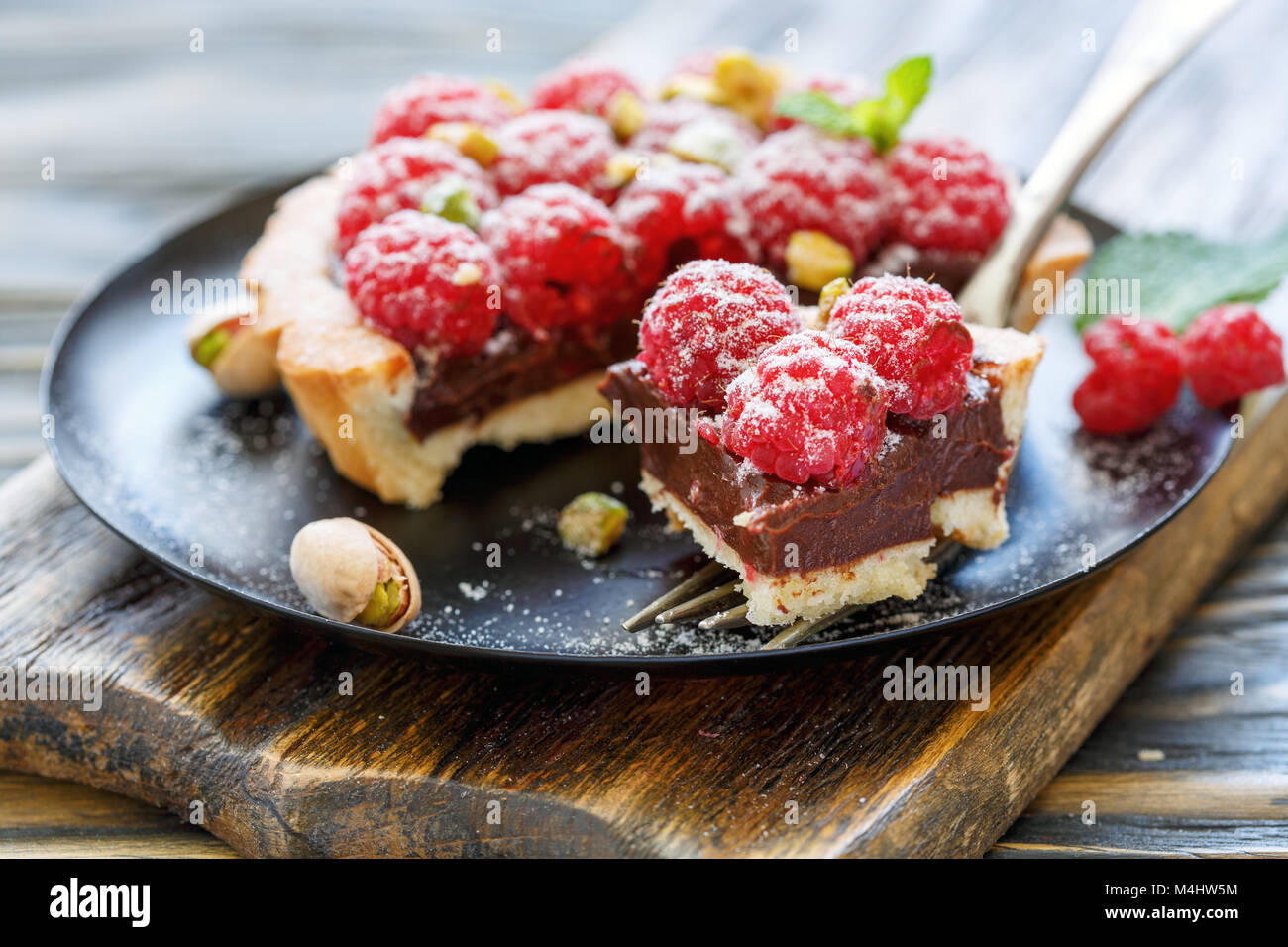 Mini tart with fresh raspberries and a fork. Stock Photo
