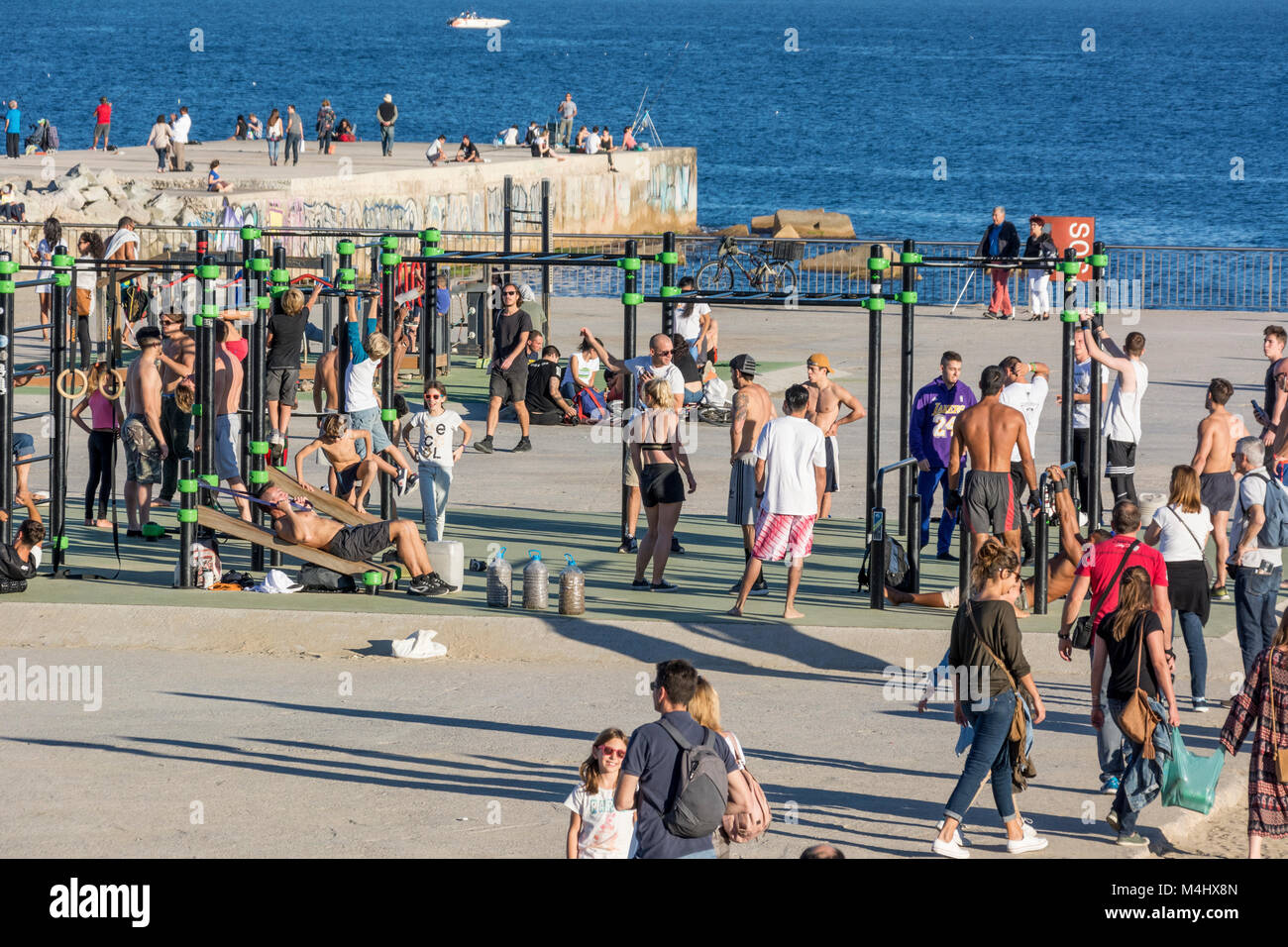 Fitnessgeräte, Turnstangen am Strand von Barcelona an einem Sonntag mit regem Besuch Stock Photo