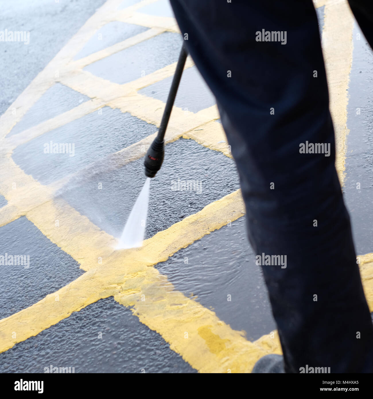 February 2018 - man jet washing the yellow lines of a disabled parking bay outside a McDonald's restaurant in Portishead, near Bristol. Stock Photo