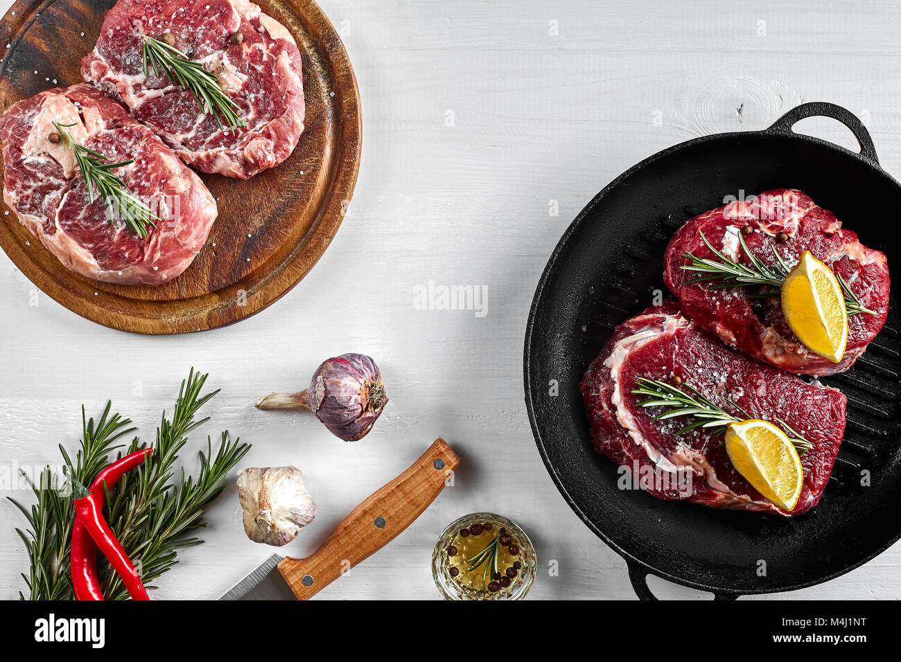 Raw juicy steaks with seasonings in a black pan ready for roasting on