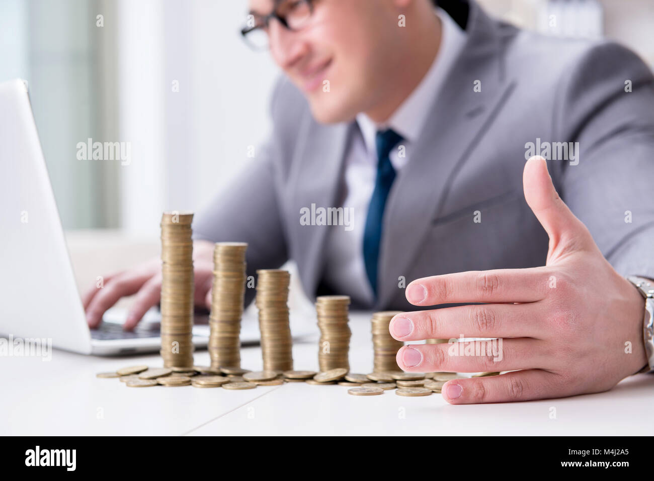 Businessman with golden coins in business growth concept Stock Photo ...