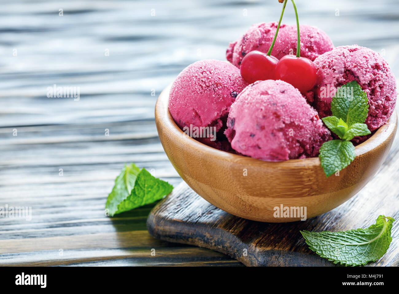 Wooden bowl with cherry ice cream. Stock Photo