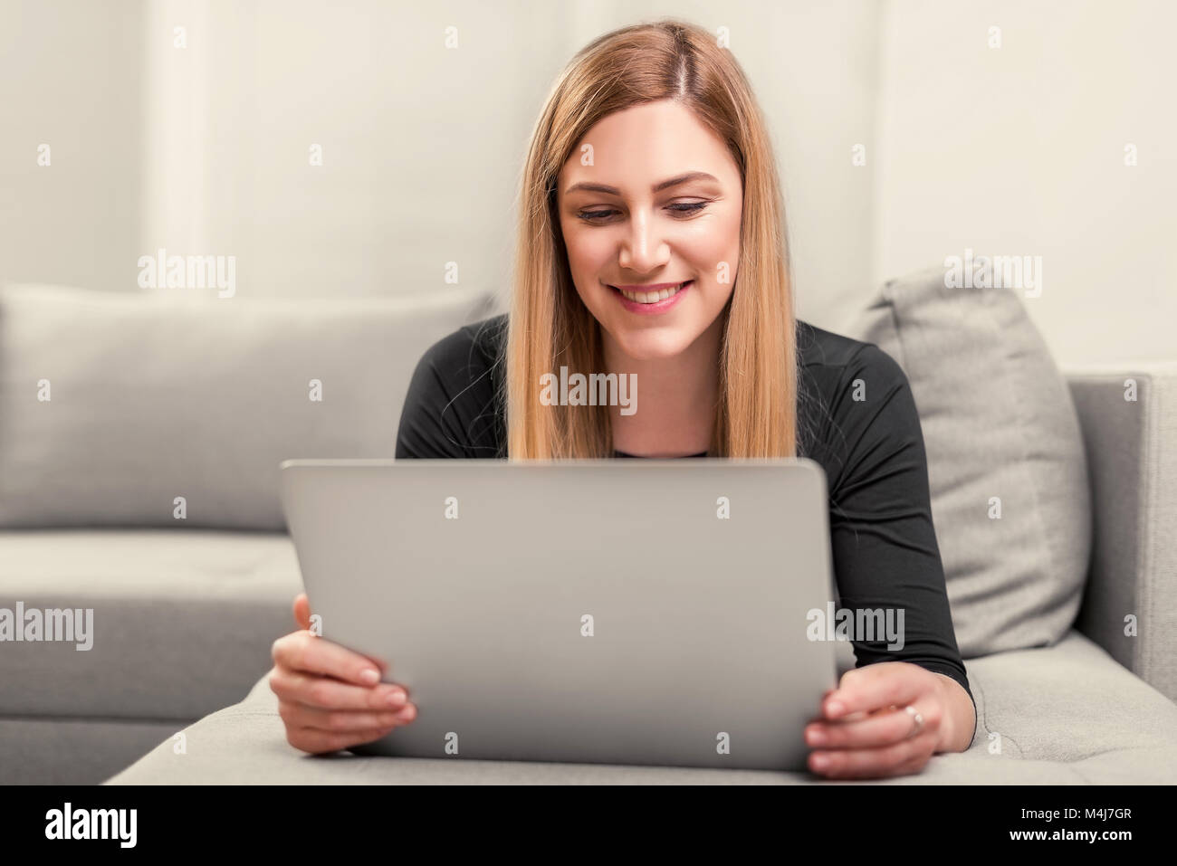 Happy blonde lying on couch hi-res stock photography and images - Alamy