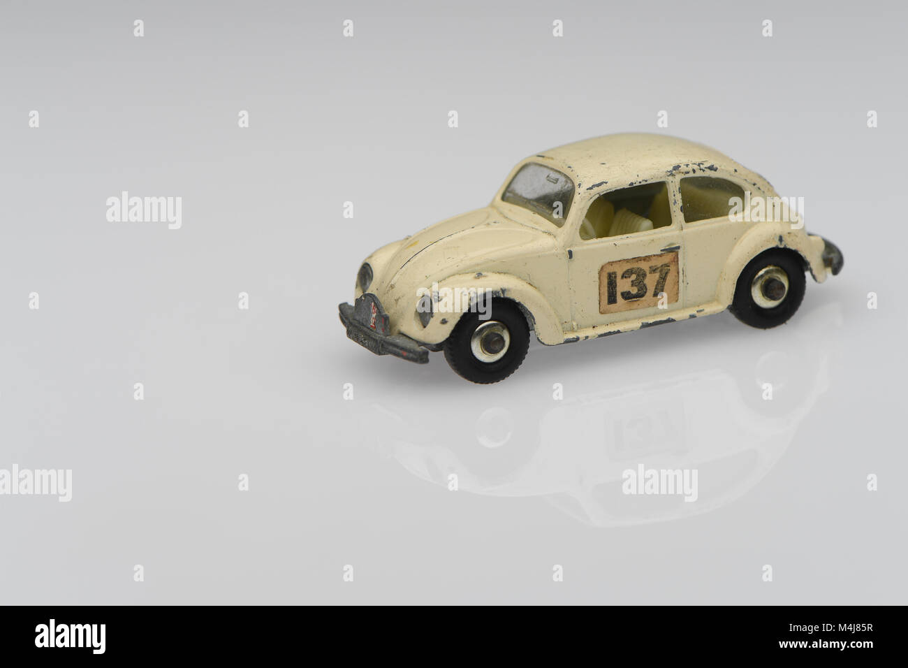 A white vintage 1500 saloon Volkswagen beetle toy race car car showing signs of use on a white background. Stock Photo