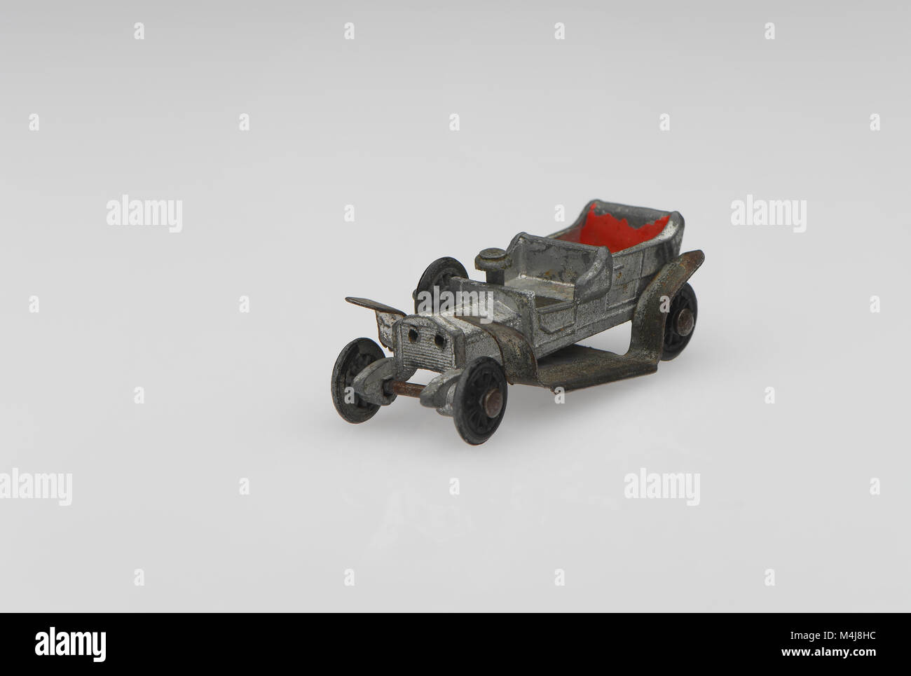 A vintage Rolls Royce Silver Ghost toy car from 1950s-60s in a well used played with condition on a white background. Stock Photo
