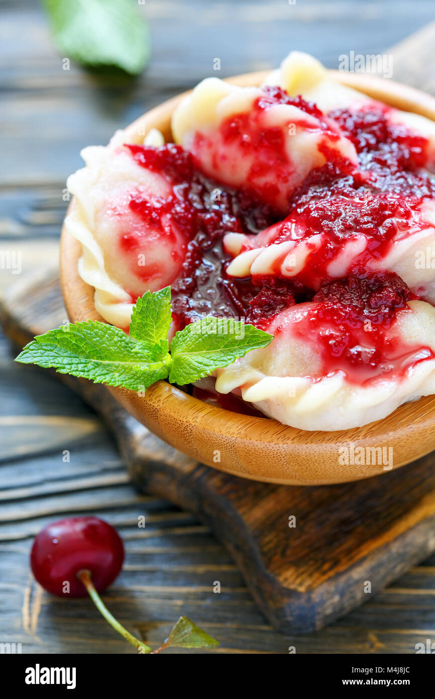 Dumplings with cherries and berry sauce. Stock Photo