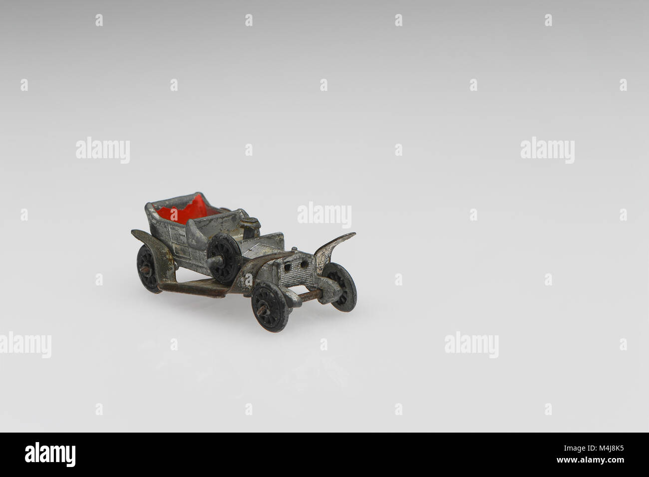 A vintage Rolls Royce Silver Ghost toy car from 1950s-60s in a well used played with condition on a white background. Stock Photo