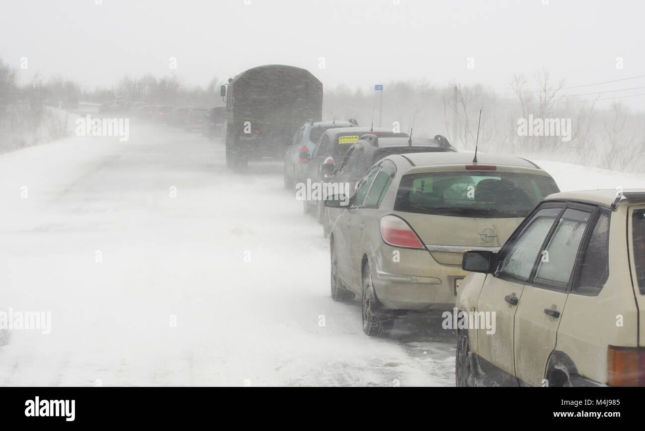 A column of vehicles stuck on the road in a snowstorm Stock Photo