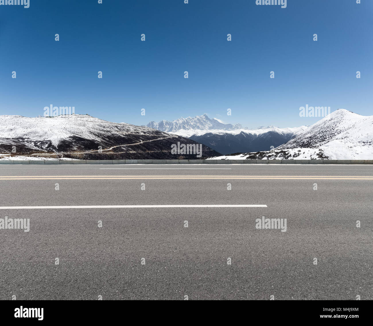 empty asphalt road with snow mountain Stock Photo