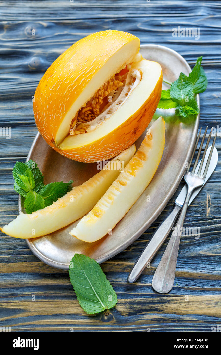 Yellow melons sliced on the metal tray. Stock Photo