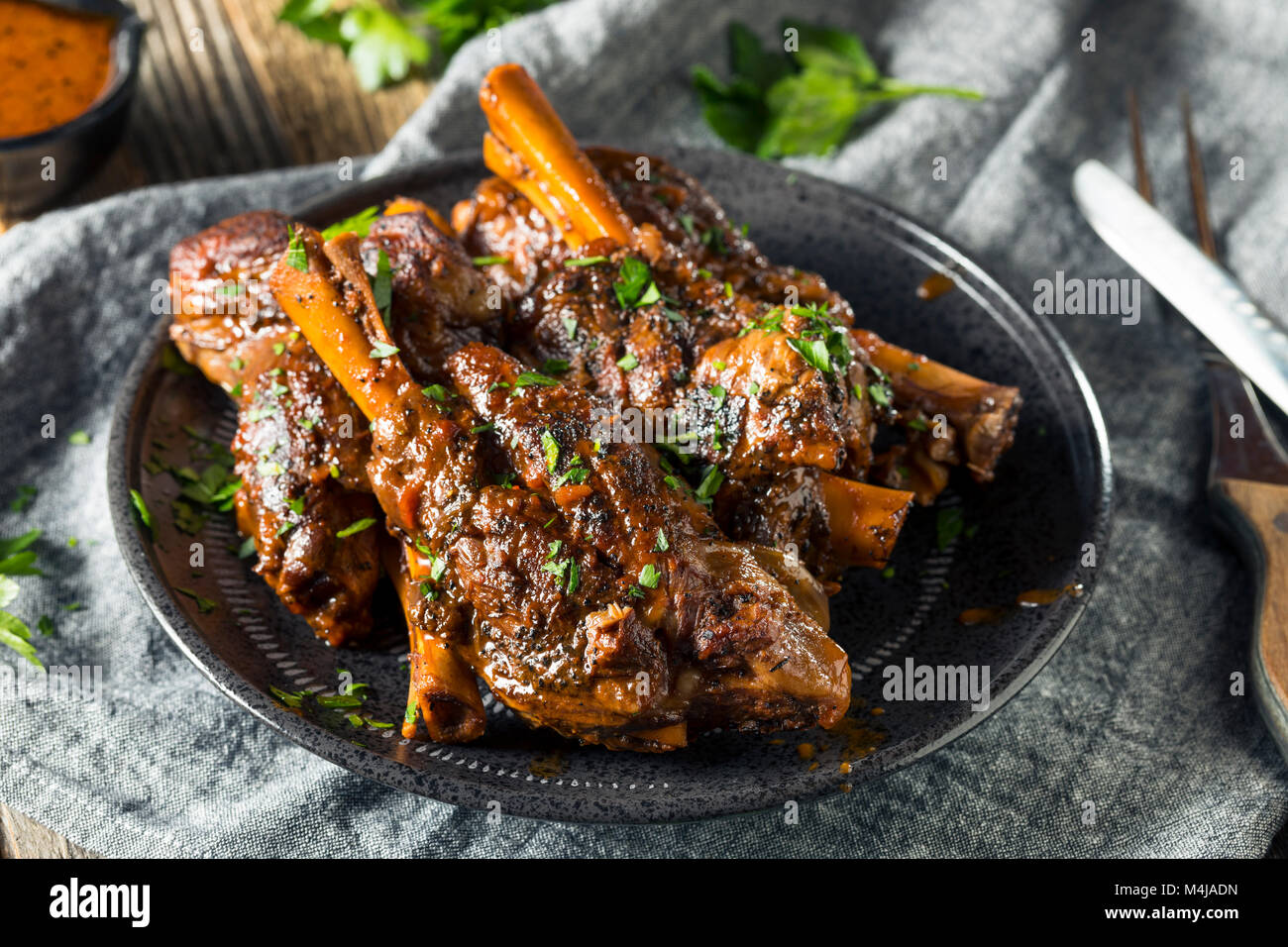 Homemade Braised Lamb Shanks with Sauce and Herbs Stock Photo