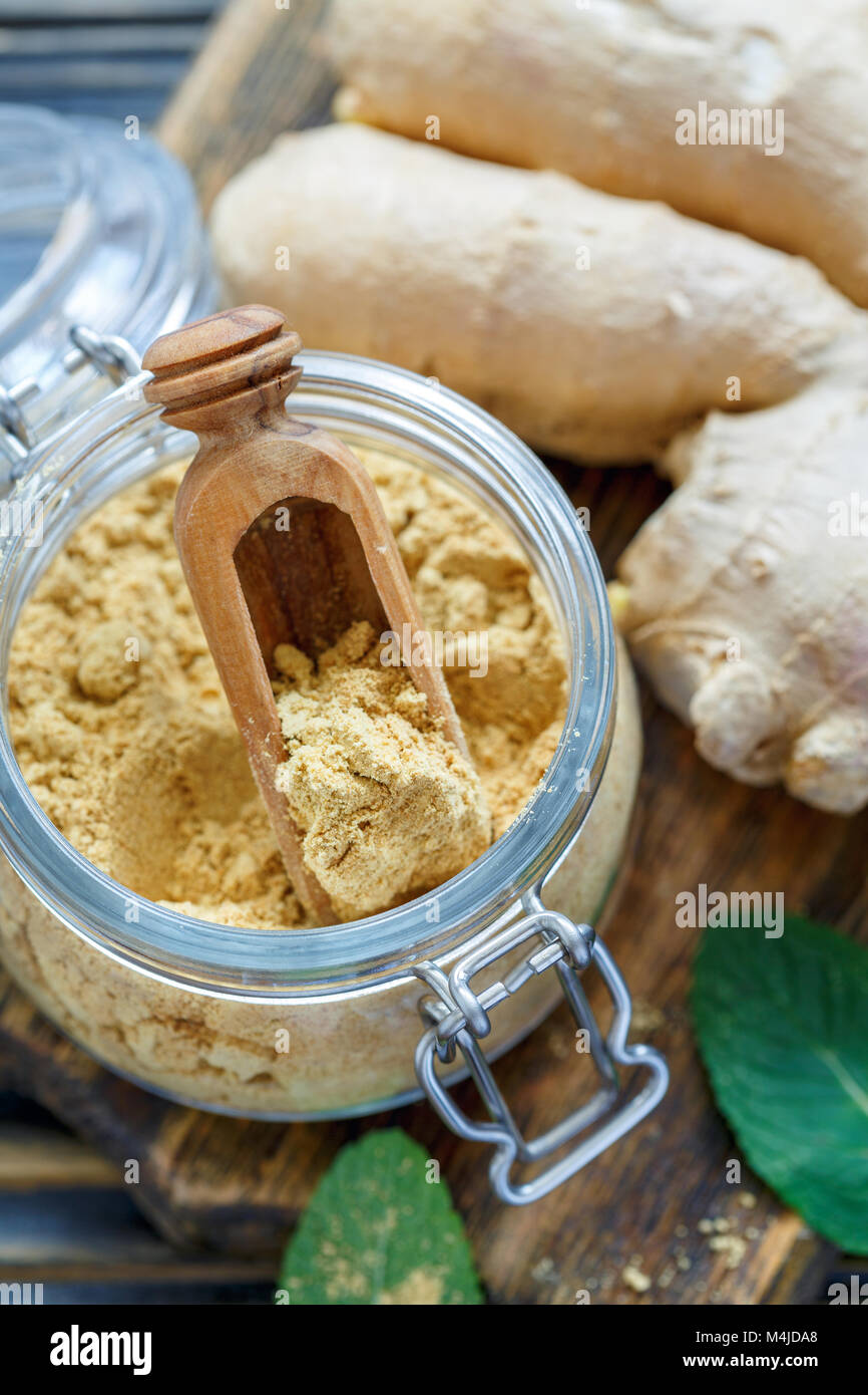 Ground ginger in a glass jar and ginger root Stock Photo Alamy