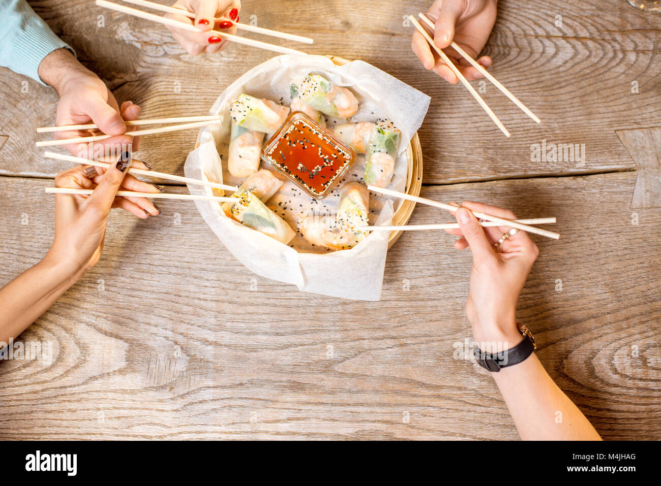 Eating with sticks rice rolls Stock Photo Alamy