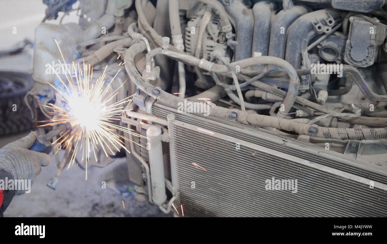 Industrial concept: worker doing welding in car auto service Stock Photo
