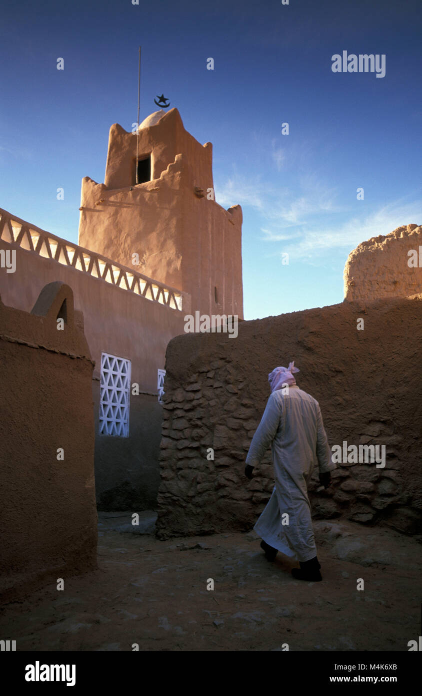 Algeria. Taghit or Tarit. Western Sand Sea. Grand Erg Occidental. Sahara desert. Oasis. Man walking in village Mosque. Stock Photo