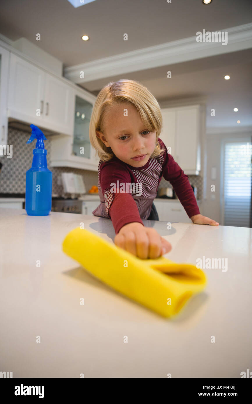 Boy cleaning kitchen worktop with rag Stock Photo Alamy