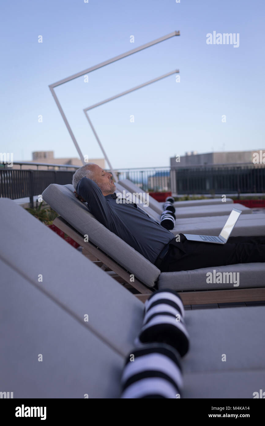 Businessman resting on a sun lounger Stock Photo