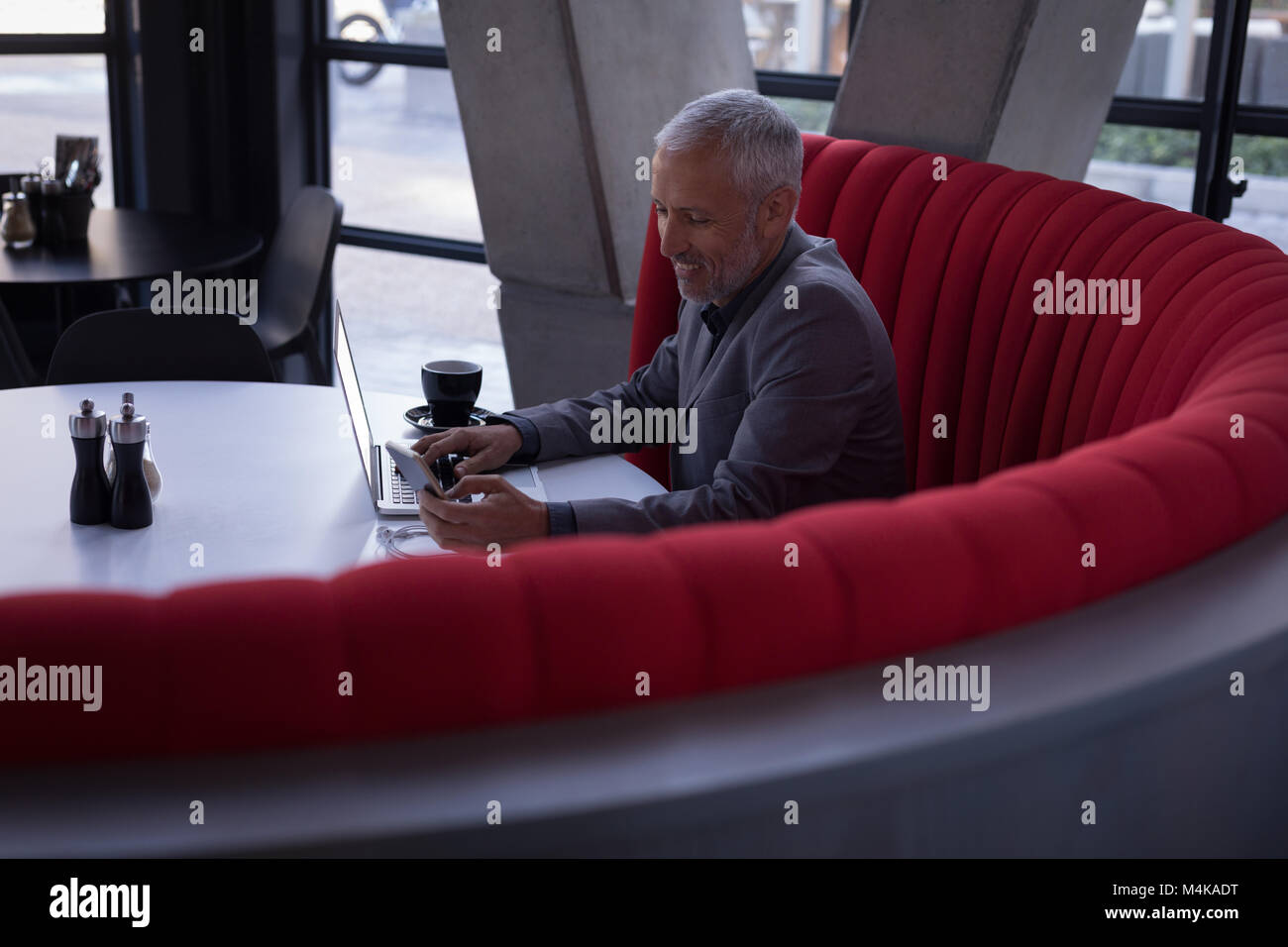Businessman using mobile phone while working on laptop Stock Photo - Alamy
