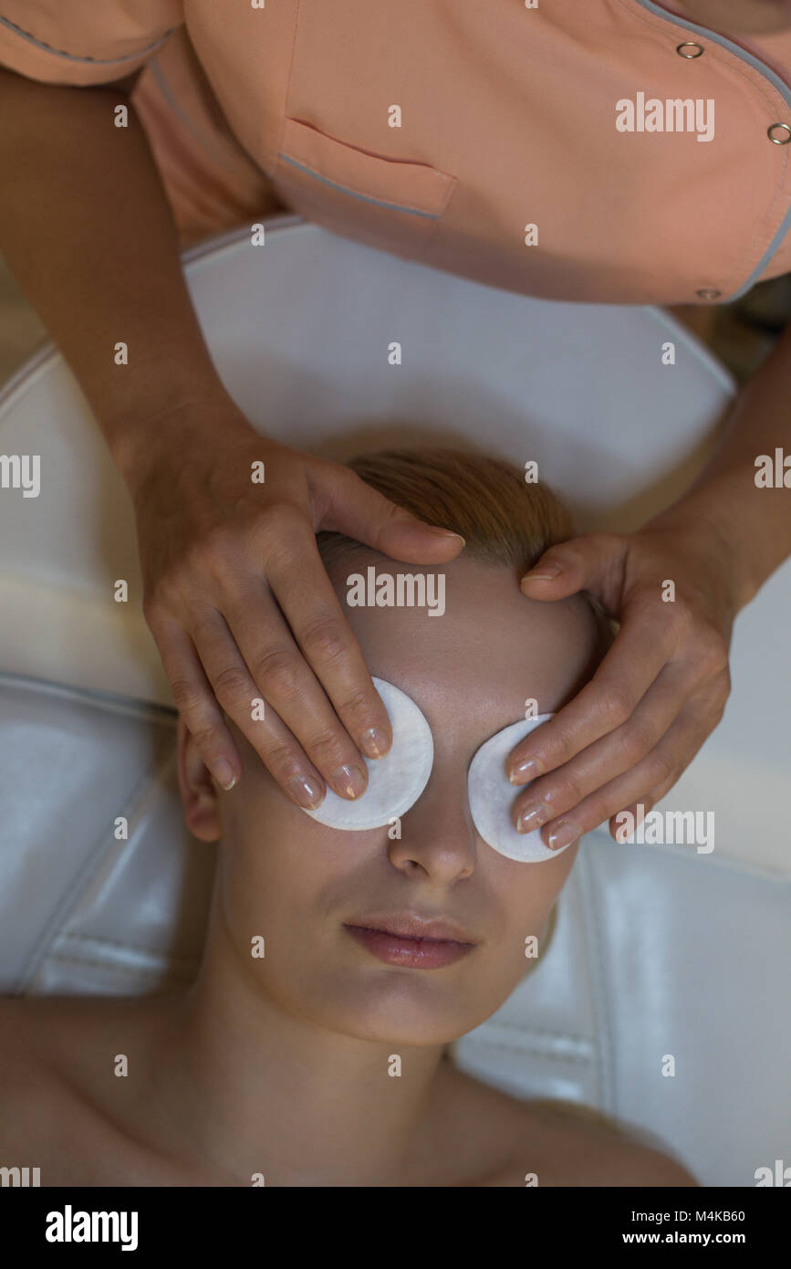Beautician placing an beauty masks on female customer eyes Stock Photo