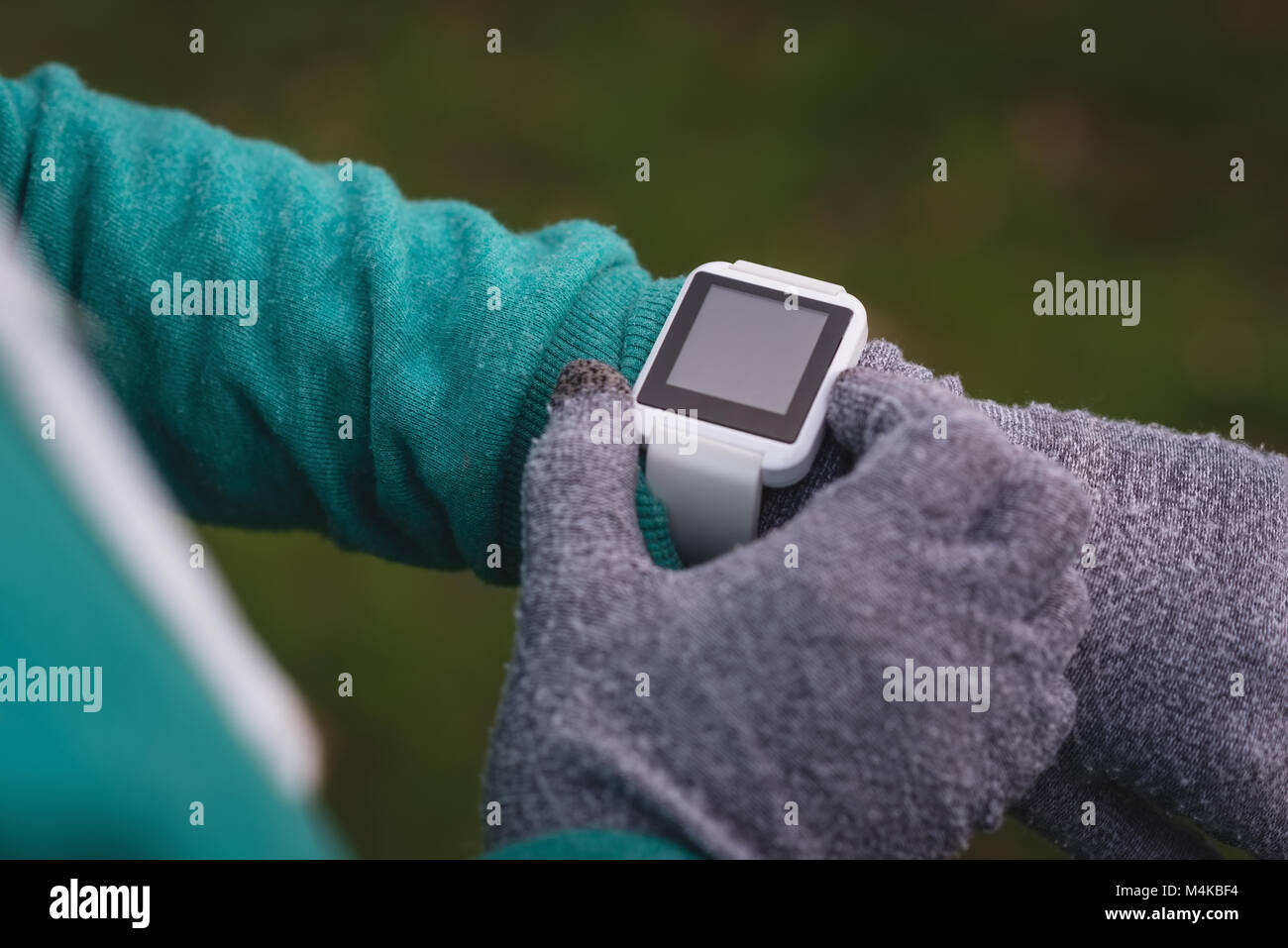 Woman using smartwatch in the park Stock Photo