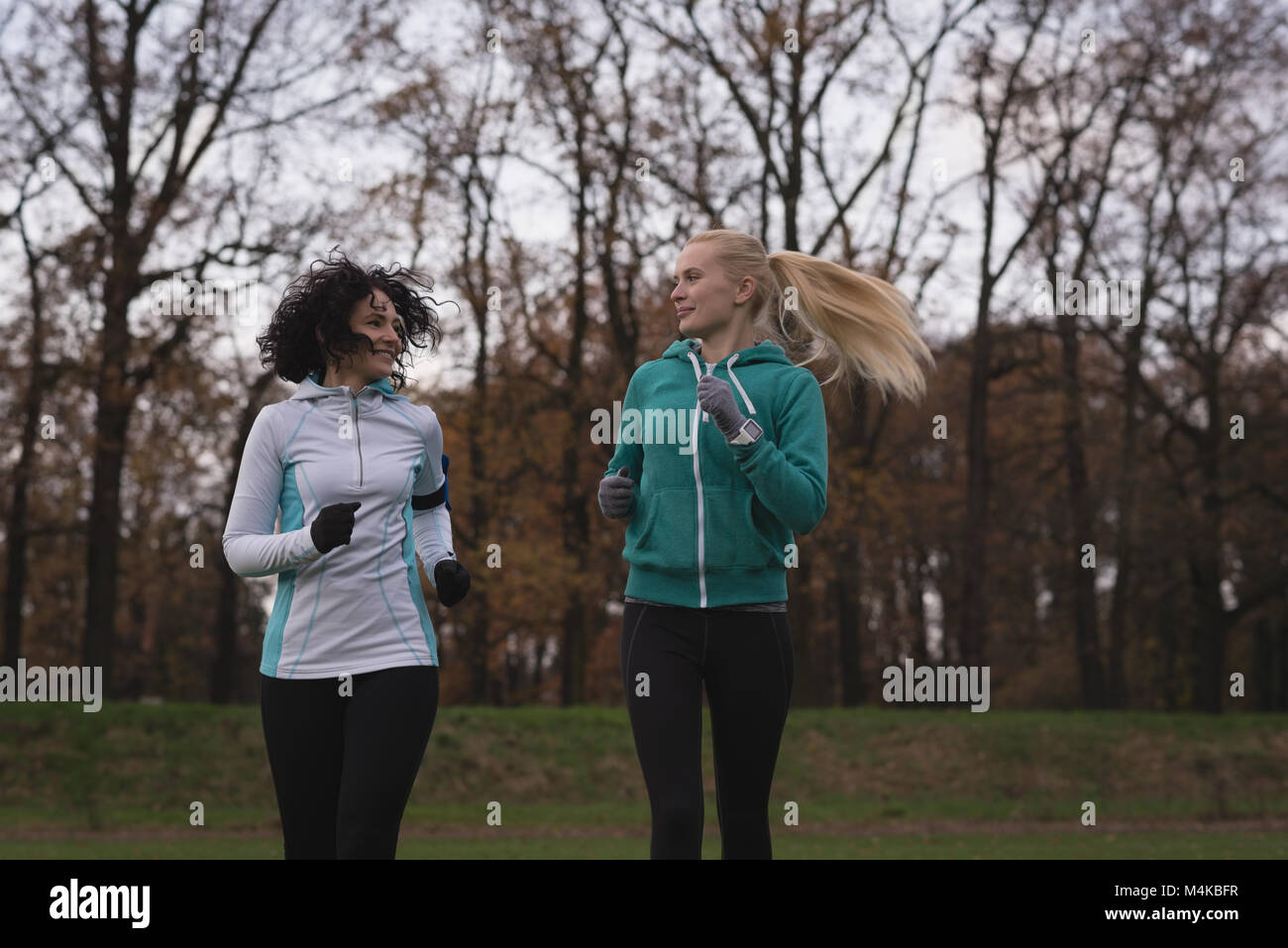 Two female friends jogging in the park Stock Photo