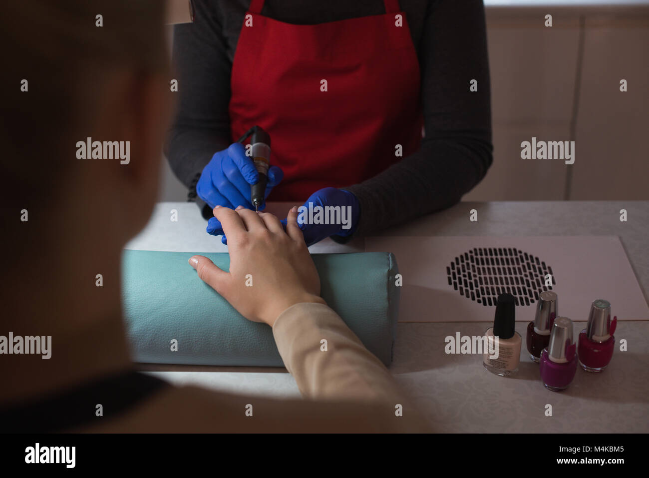 Beautician giving manicure treatment to female customer Stock Photo