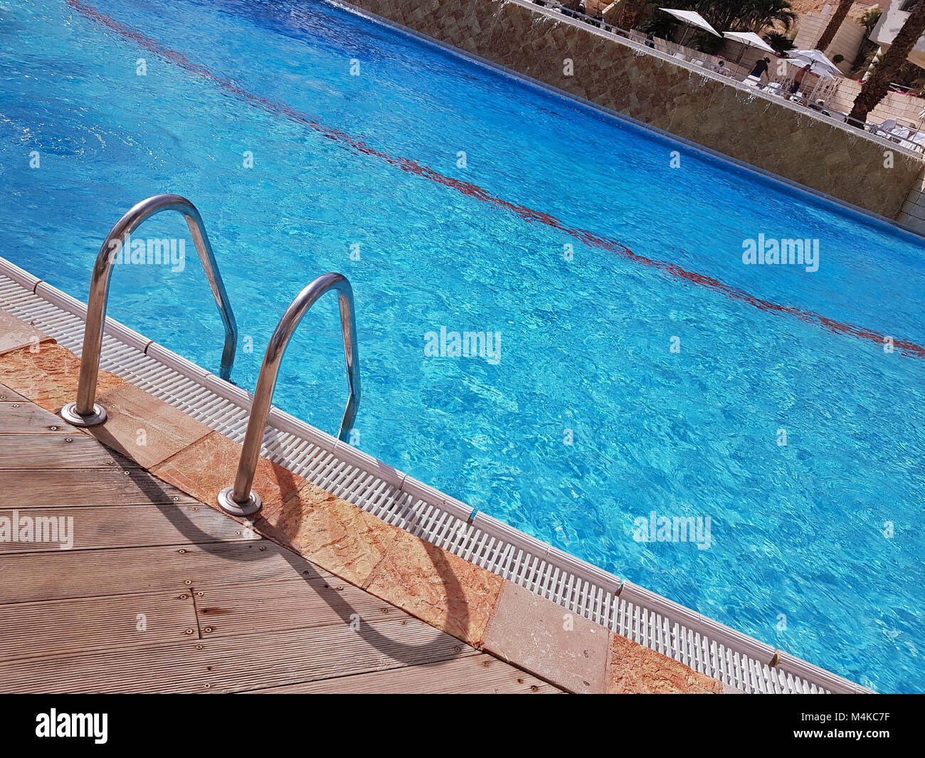 Grab bars ladder in the blue luxury swimming pool.Conceptual image for vacation,refreshment and