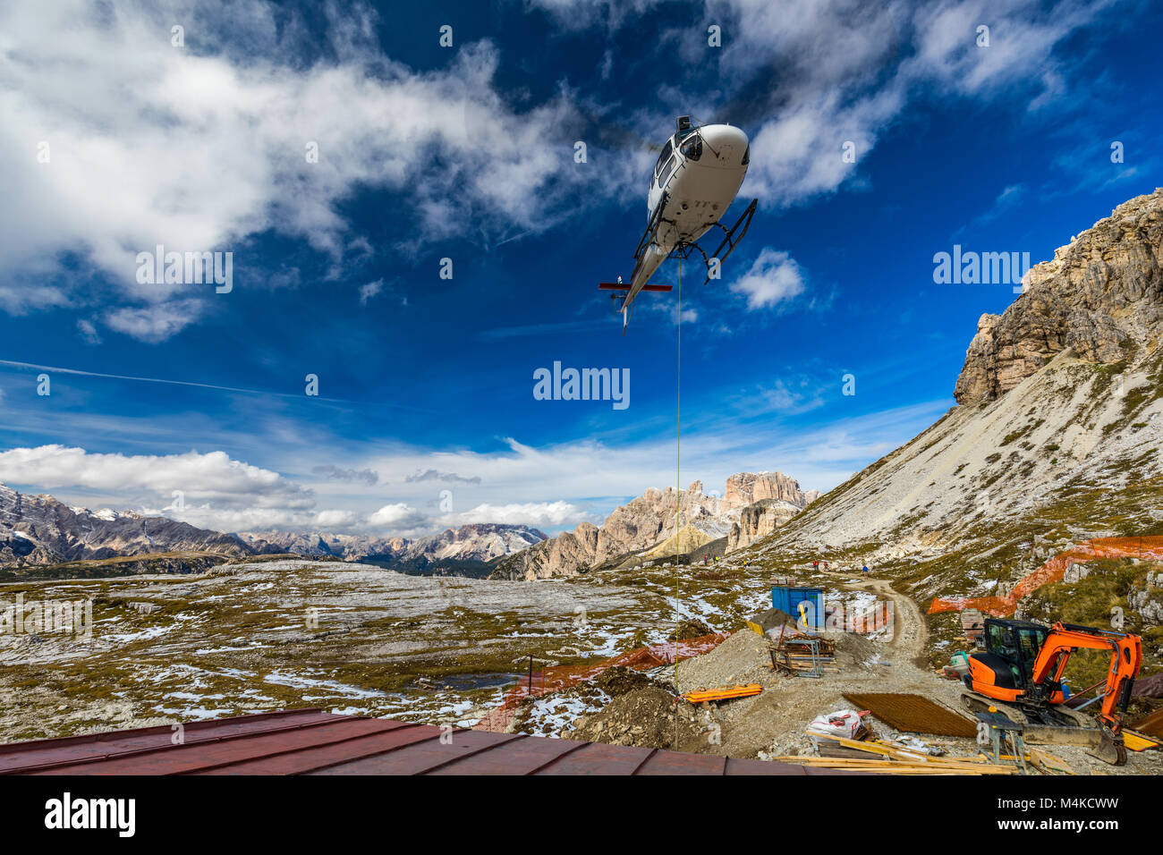 Helicopter used for rescue operations also for bringing construction materials, on the ground Tre Cime di Lavaredo in Dolomites, Italy. Stock Photo